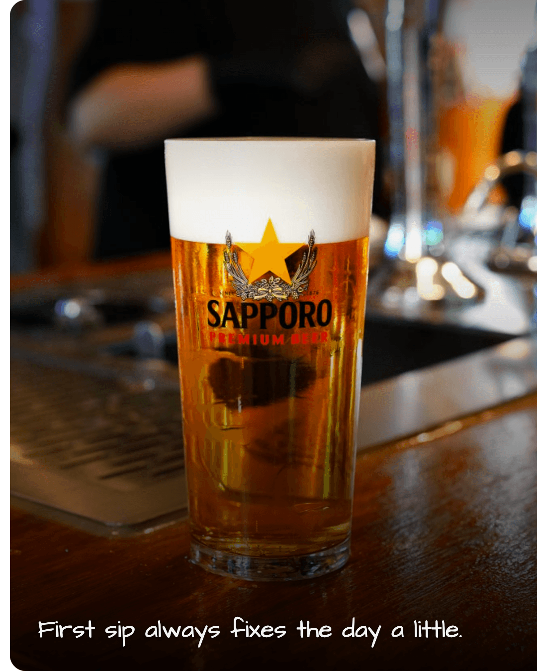 Kanpai Beer glass of Sapporo on wooden counter